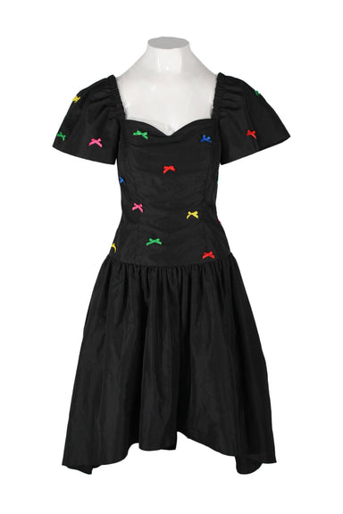 front angle of vintage party dress on feminine mannequin featuring multicolor bow embellishment at upper, dropped waist, and sweetheart neckline.