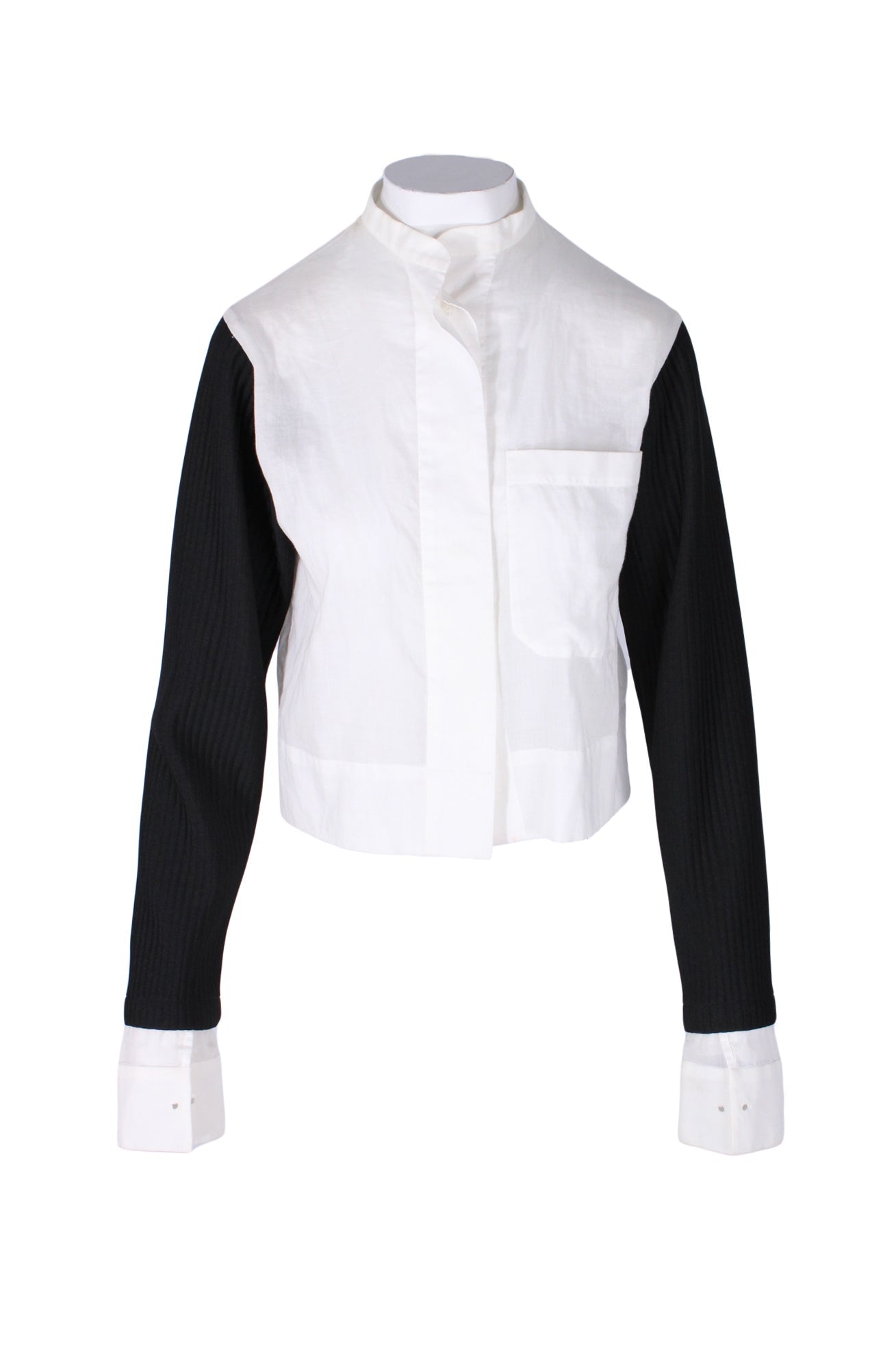  front angle index black and white long sleeve stylized top on feminine mannequin torso featuring semi-sheer woven main & french cuffs, contrast rib knit sleeves, overlapping band collar, chest patch pocket, and concealed front button closure.