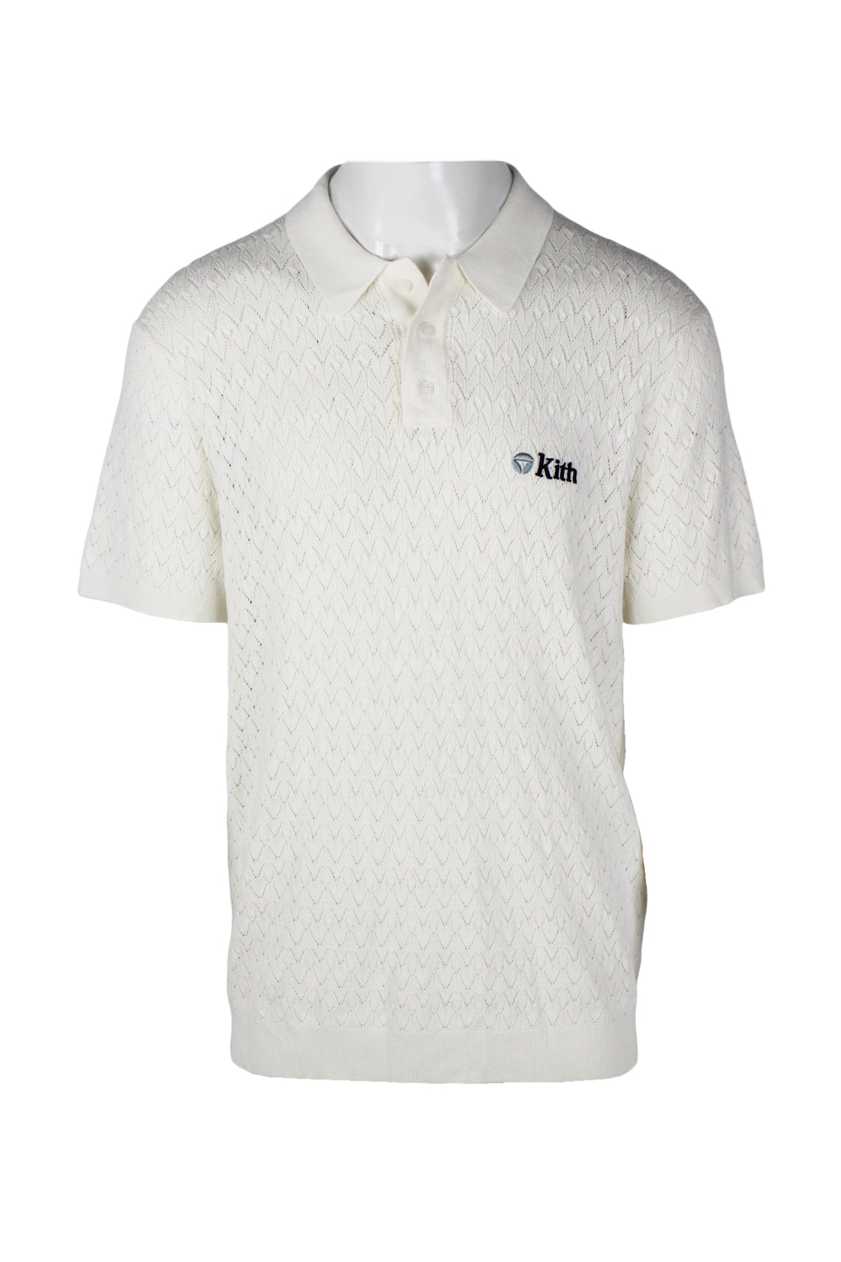 front angle of taylor made with kith cream crocheted polo shirt. features branding over heart in dark blue embroidery with text 'kith', ribbed collar/three button placket/cuffs/hem, and all over semi-sheer crochet pattern throughout. 