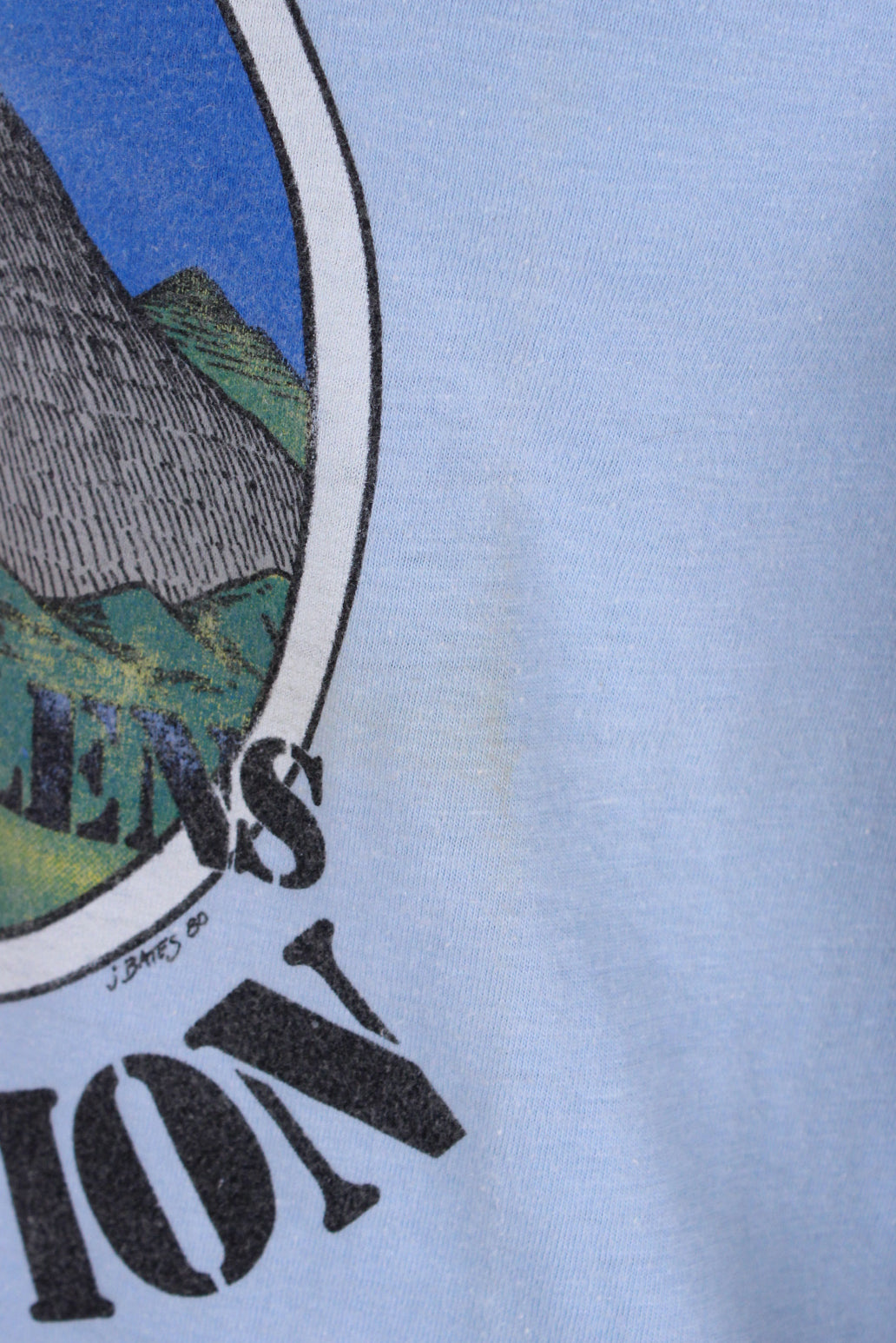 front detail view of mark next to graphic of shirt.