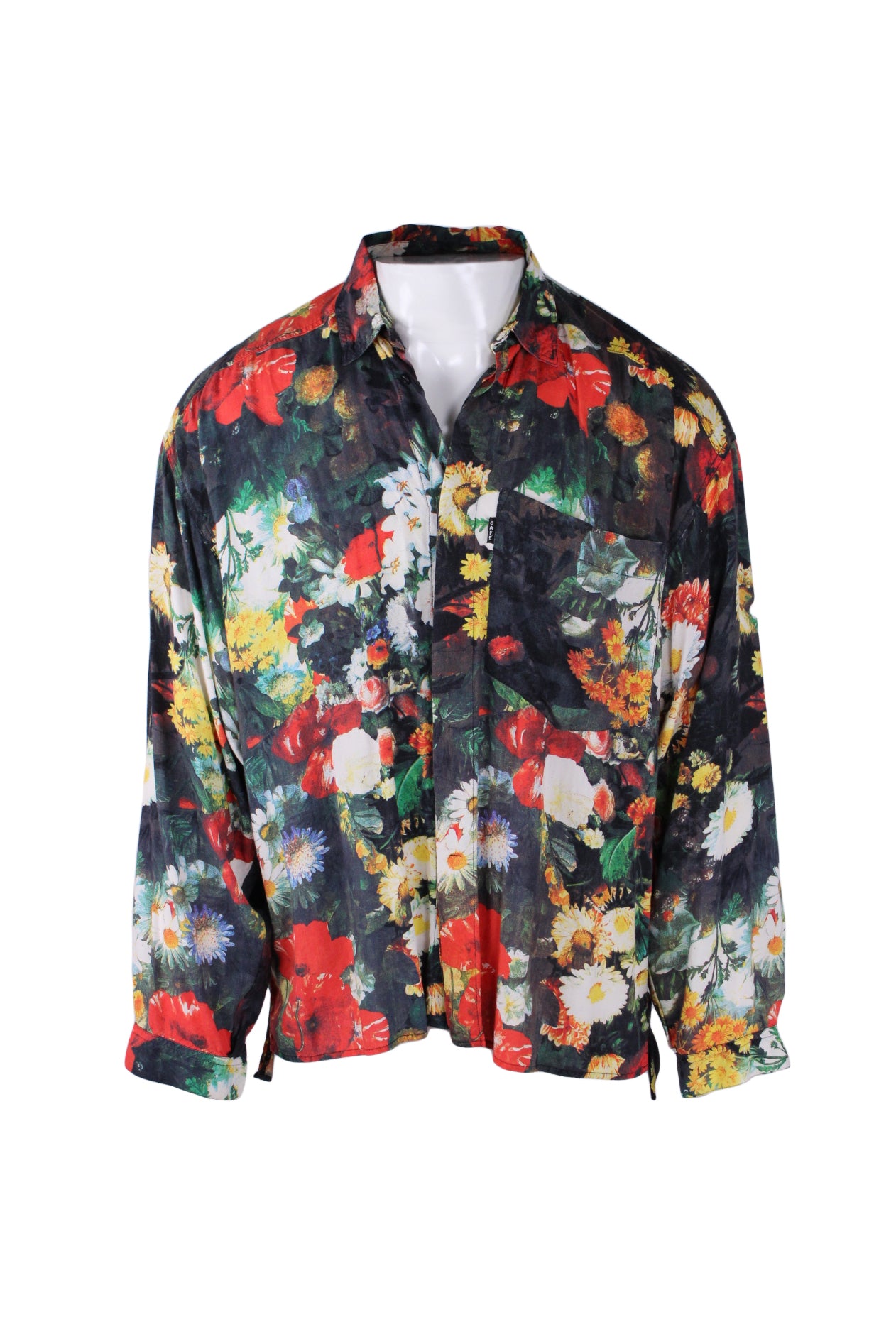front angle of vintage cafe multicolored floral button up shirt on masc mannequin. features single pocket over heart with small embroidered branded patch 'cafe' , small pointed collar, buttoned sleeves, covered button closure up center, and all over abstract jewel toned print throughout. 
