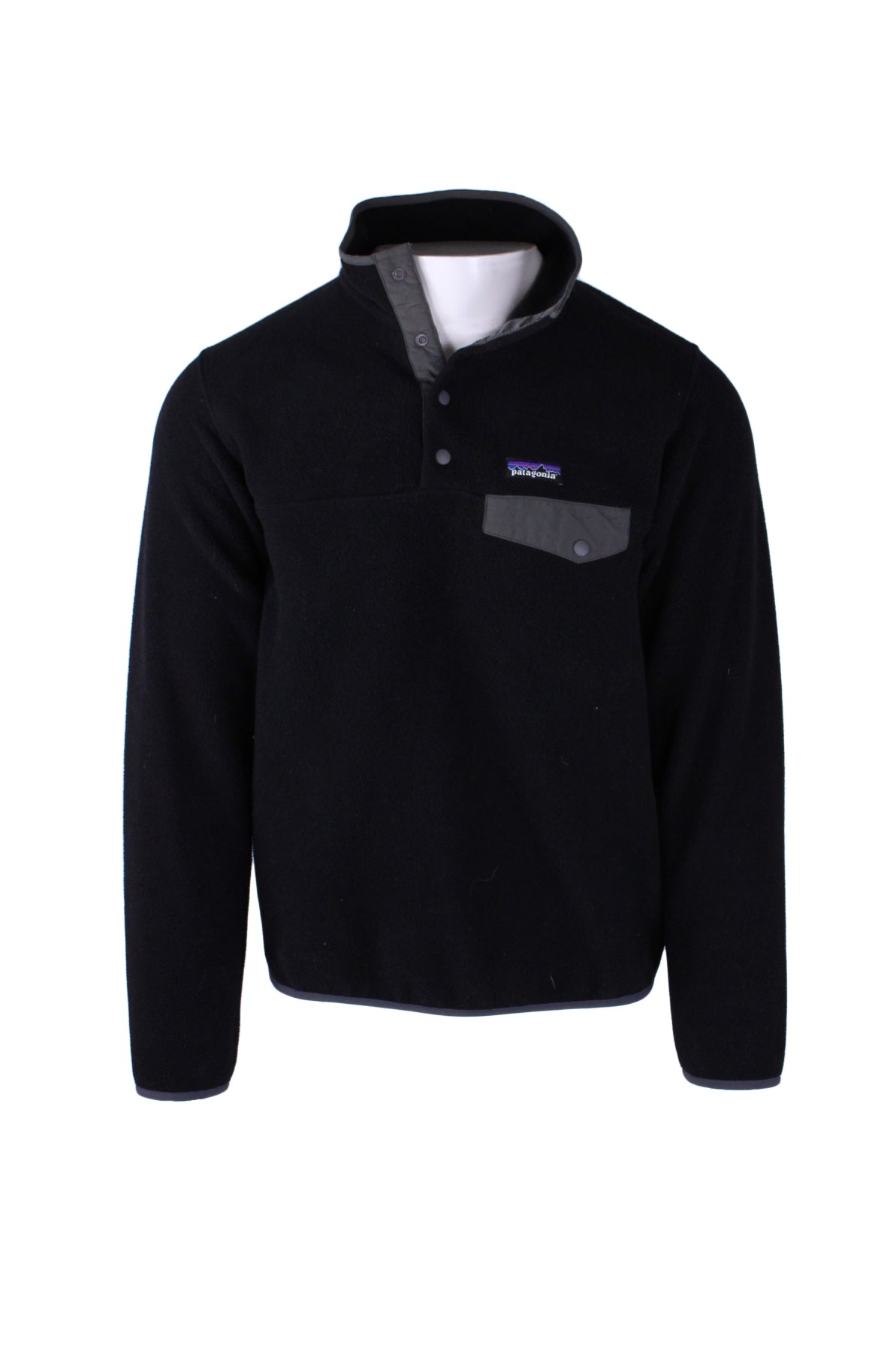 front angle of patagonia synchilla black fleece pull-over. features grey flap snap heart pocket, branded patch above pocket with text 'patagonia', stand up collar, four snap half placket, and grey piping.