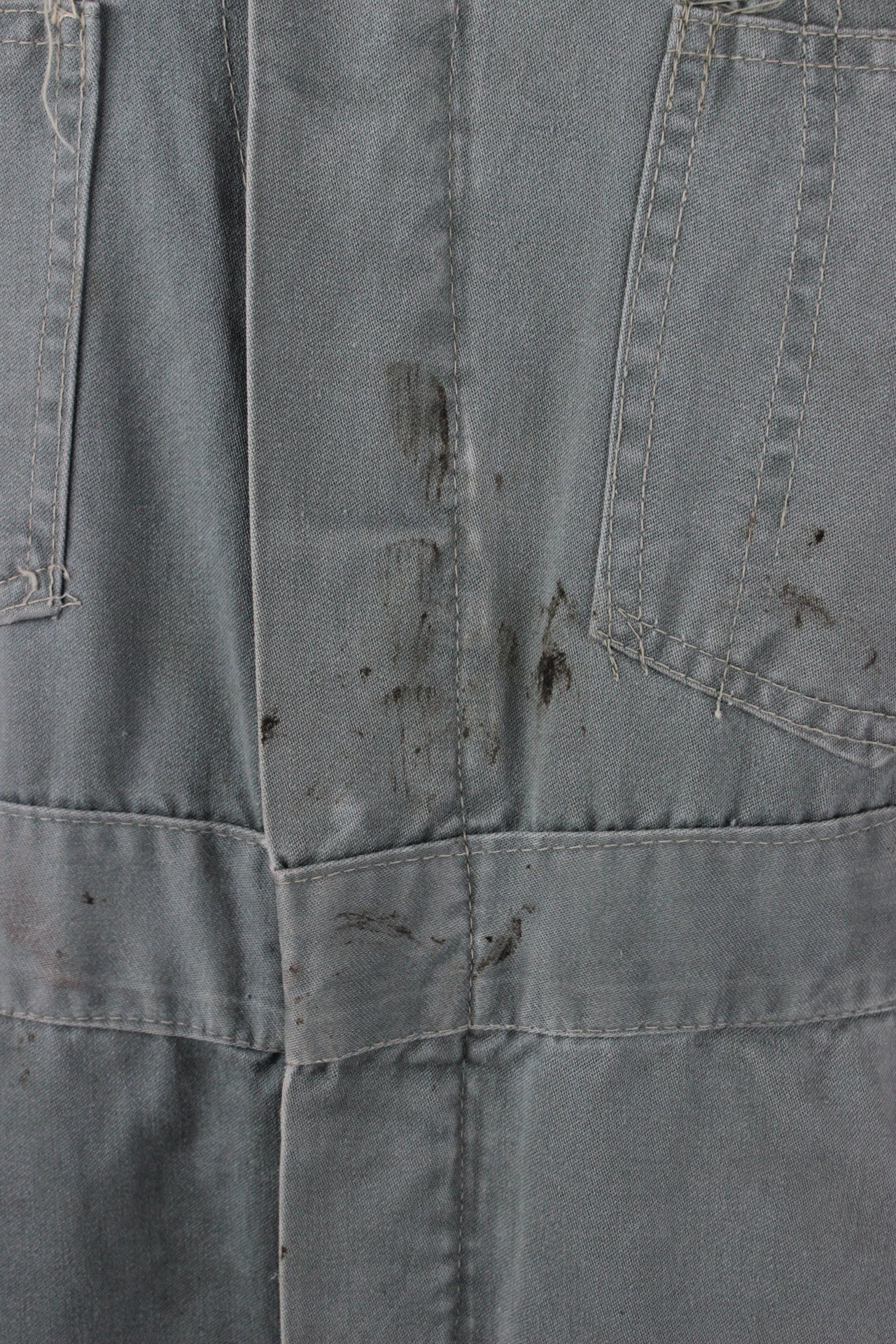 detail views of stains at placket of coveralls.