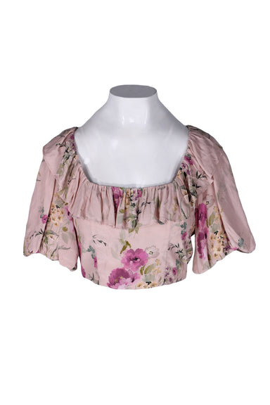 front angle yumi kim dusty pink/multicolor floral print crop top on feminine mannequin torso featuring short puff sleeves and ruffled scoop neckline.