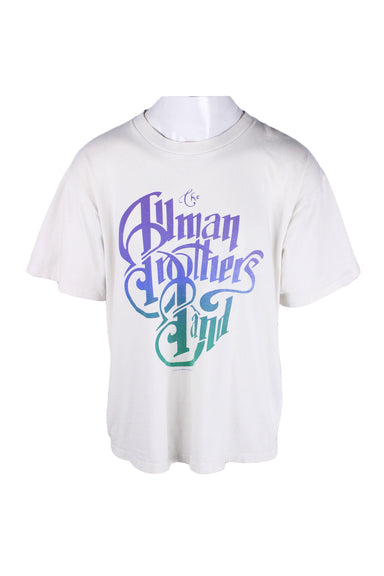 front angle of vintage wild oats white the allman brothers band t-shirt on masc mannequin. features purple/blue/green gradient screen print of band name 'the allman brothers band', ribbed rounded collar, short sleeves, and single stitch hem/cuffs. text '1995 abs merchandising co inc' below print. 