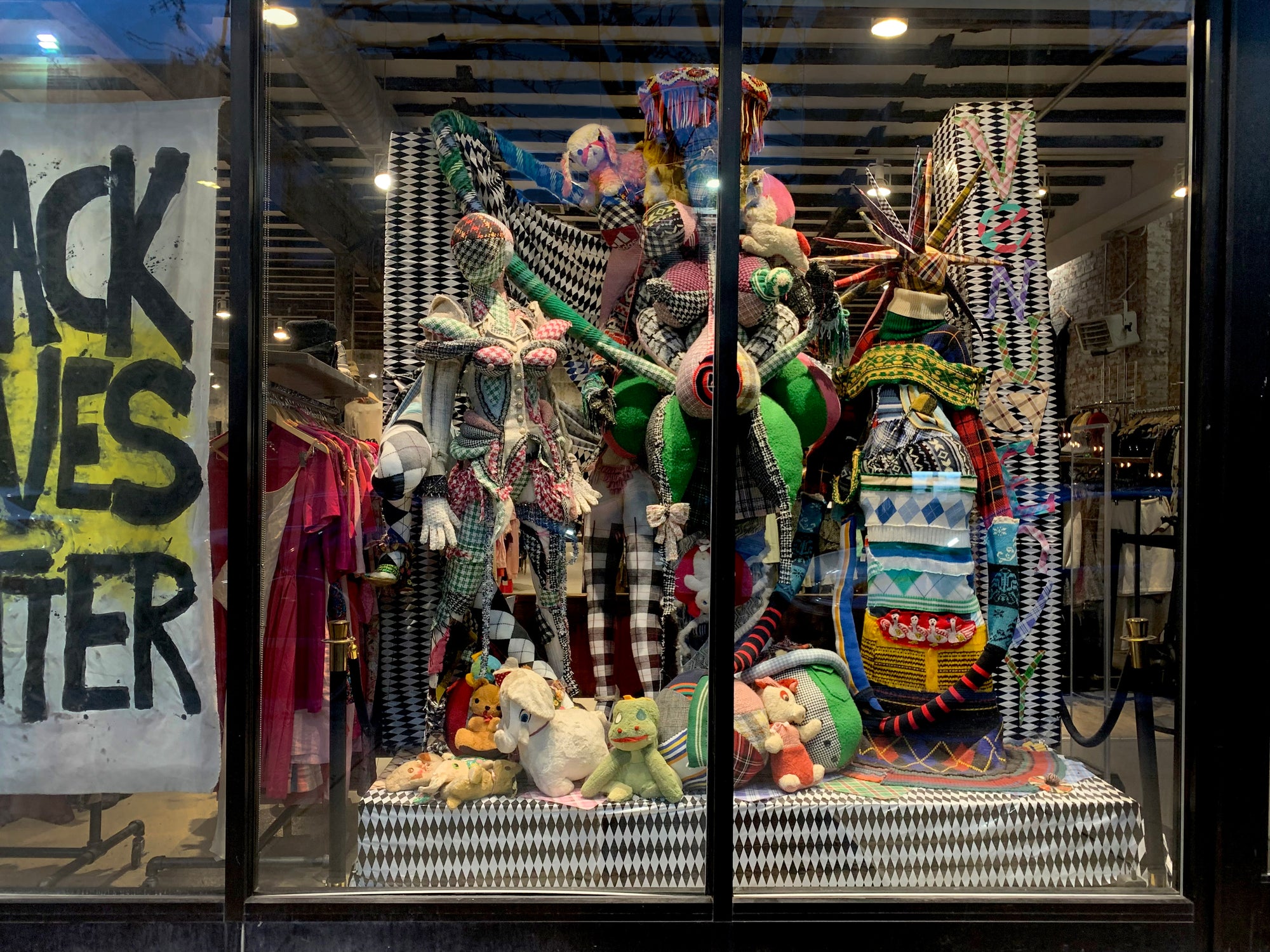 store window display showing crafty mannequins and vintage stuffed animals