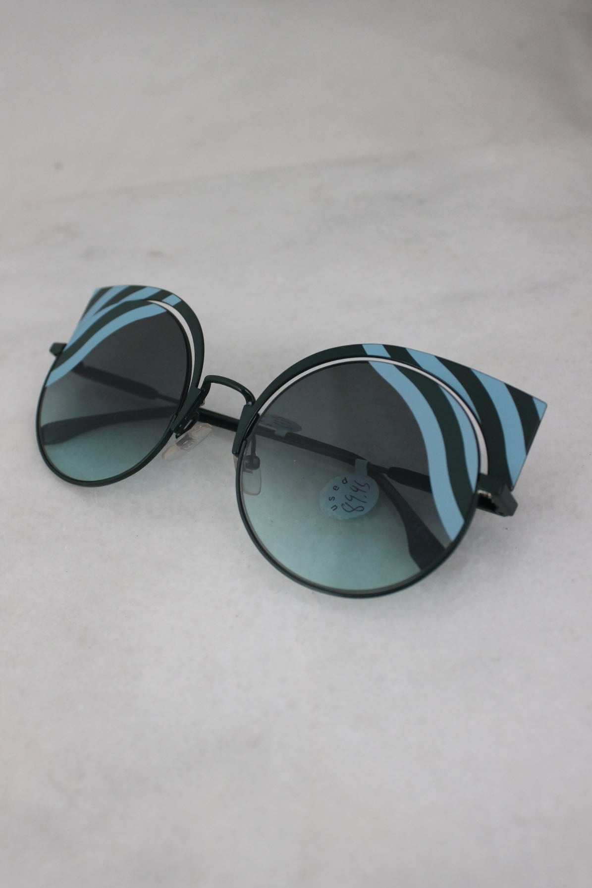 fendi "hypnoshine" green metal sunglasses. features circular blue gradient tinted lenses with metal cat eye silhouette, light blue color-blocked fluid accents that go across the lens