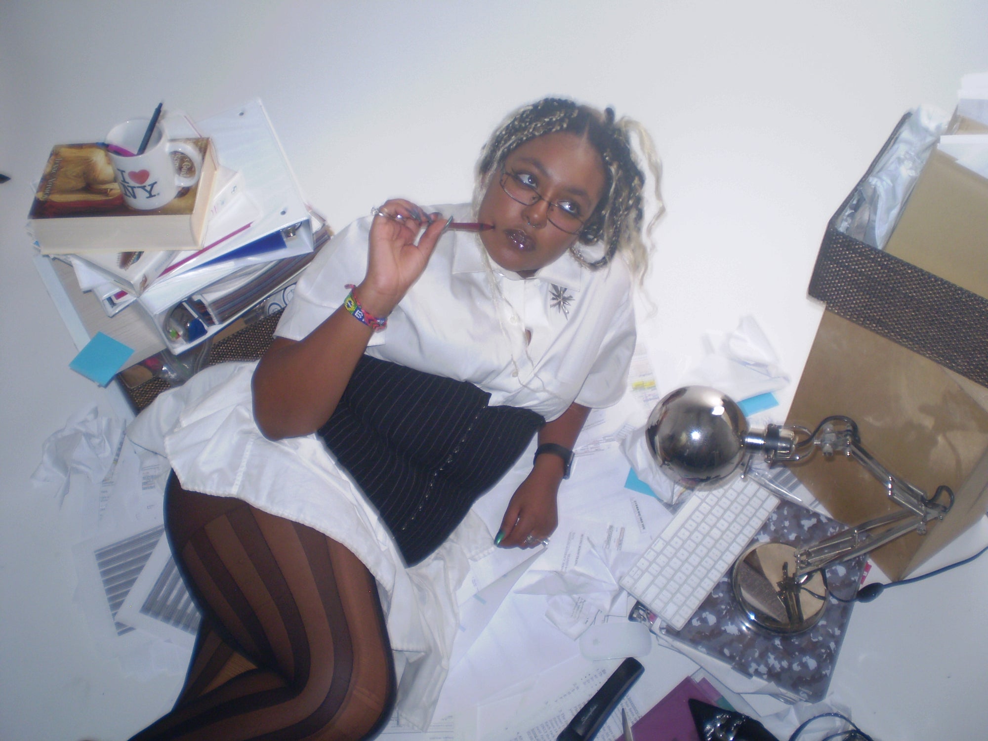 editorial of Person lying on a ground with books, a computer, and office supplies around them.