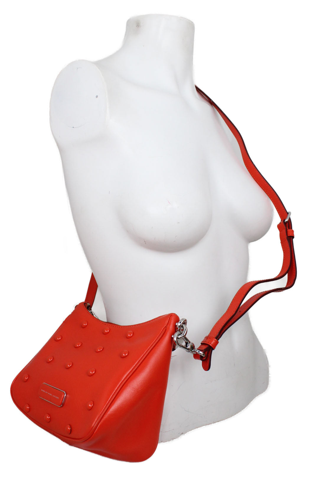 side view of marc by marc jacobs sample orange cross body bag. features orange studs and triangular side panel, handbag strap and longer strap. 