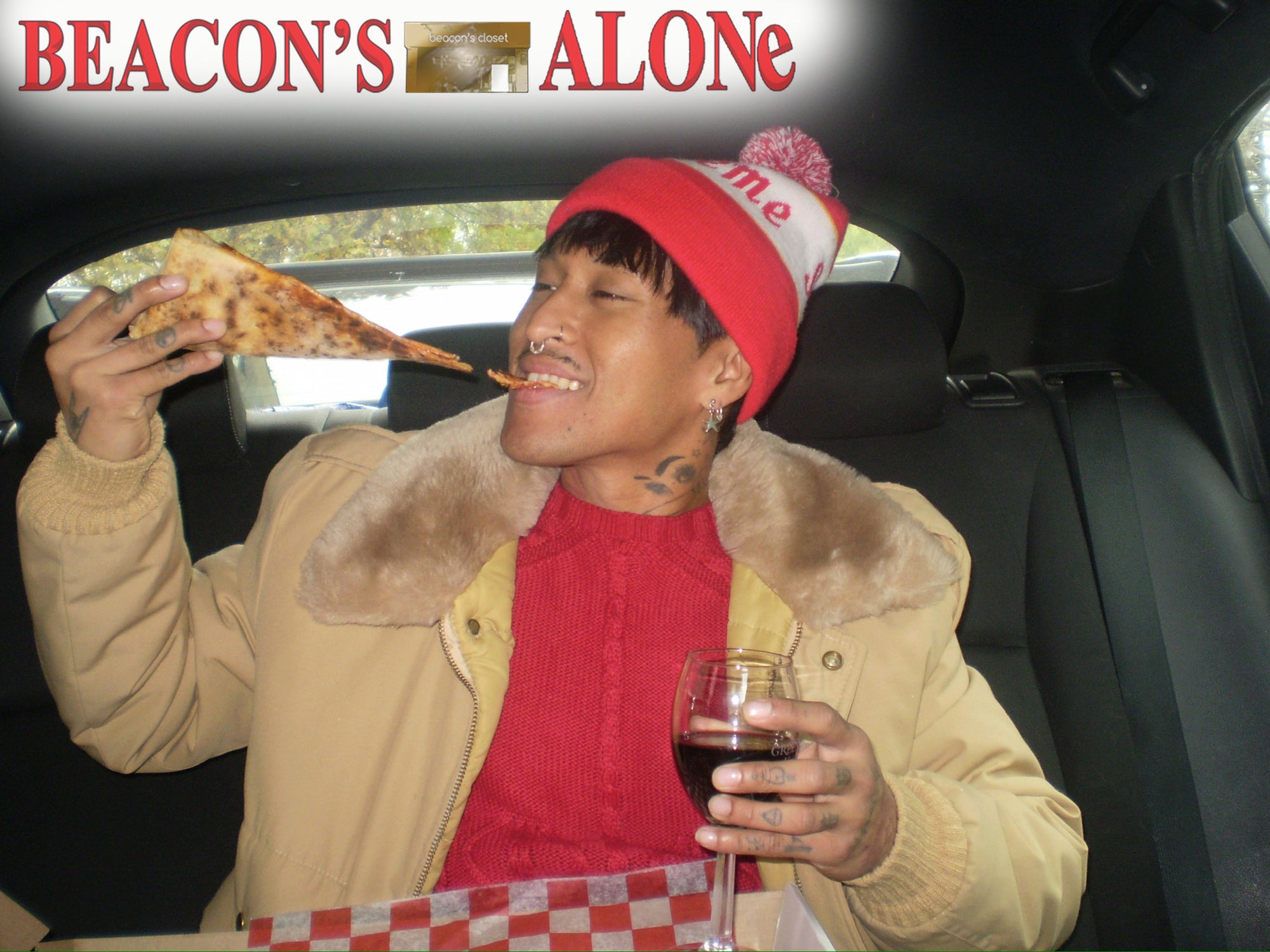 Person in a car eating pizza and drinking wine with 'Beacon's Alone' text above