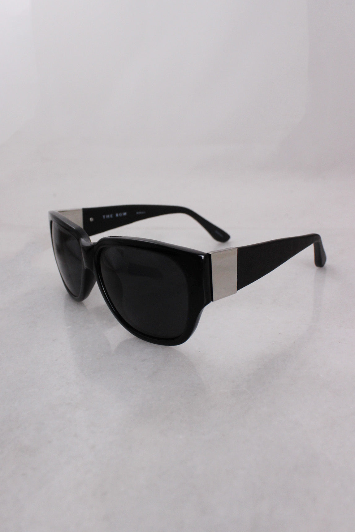 corner angle of sunglasses. silver toned hardware on temples. leather covered arms. 