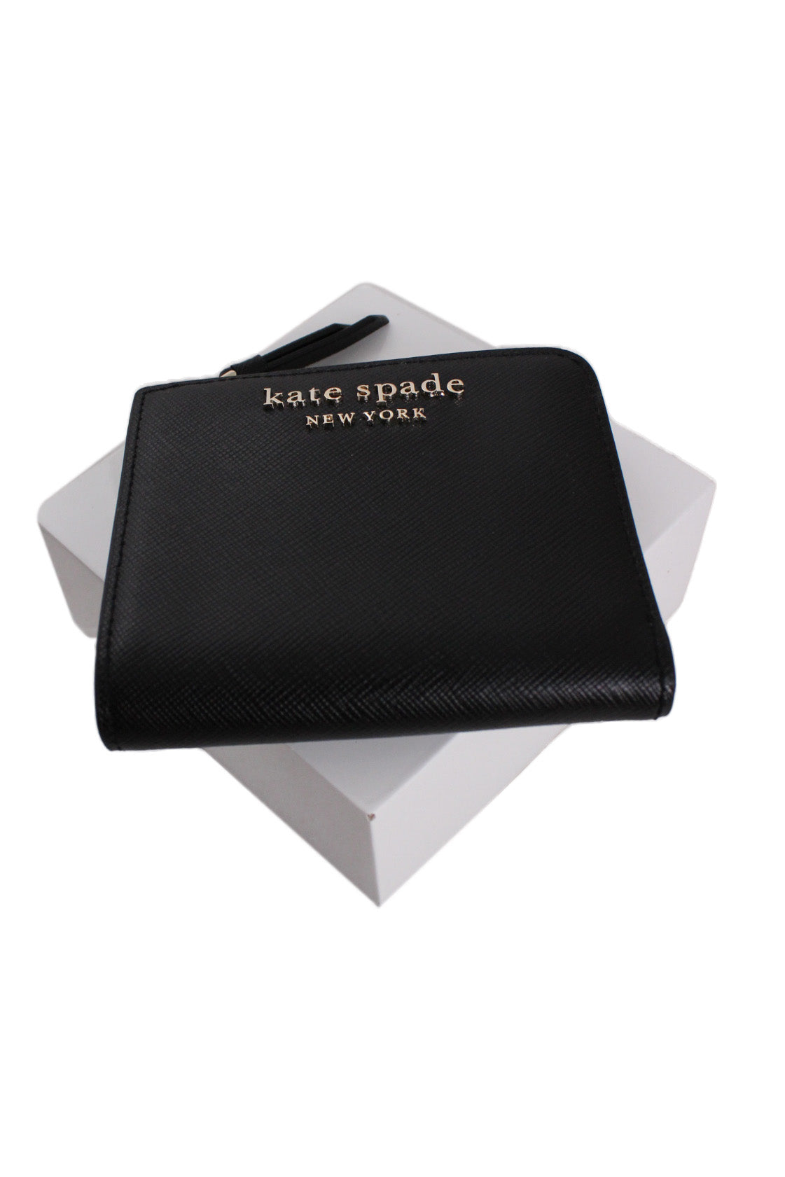 above three-quarter angle kate spade black ‘cameron’ bifold wallet featuring 'kate spade' 'new york' gold-toned text.