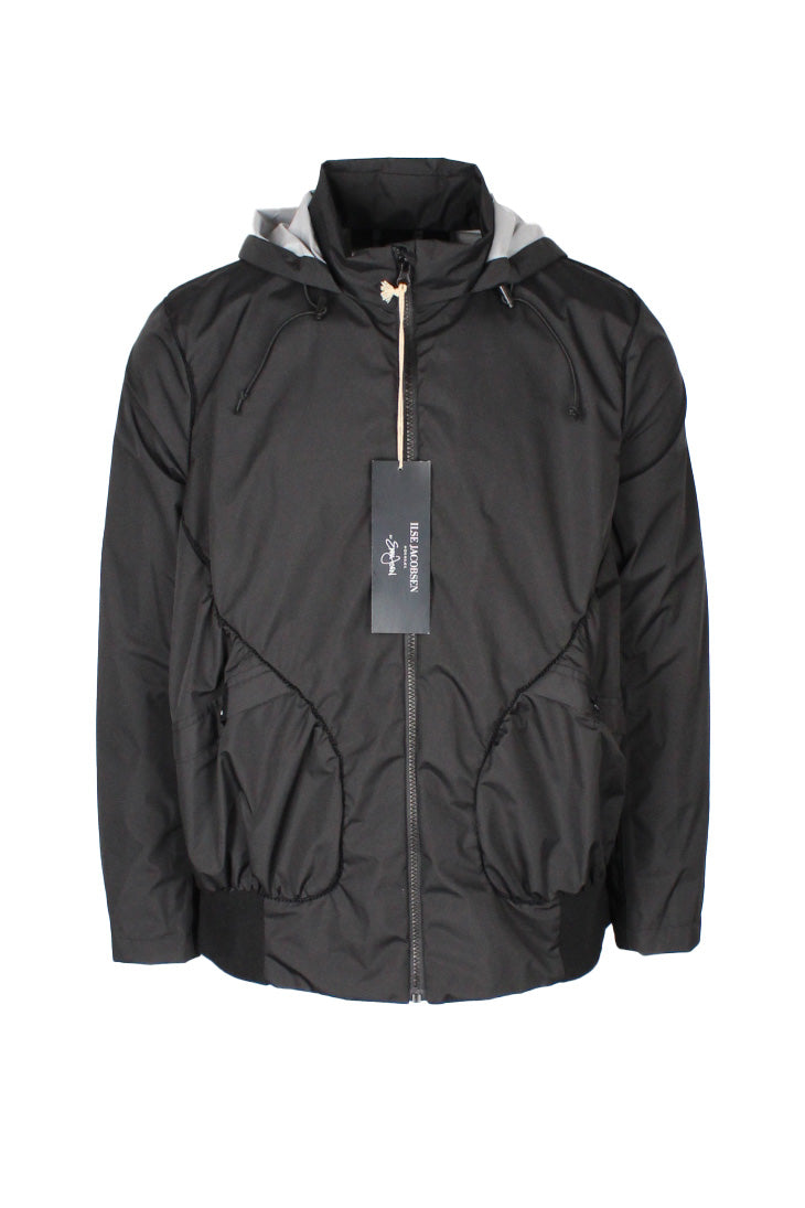 front view of isle jacobsen hornback by emma jorn black zip up ‘erain’ jacket. features front snap hand pockets, ribbed hem, and drawstrings at hood that folds/snaps into collar.