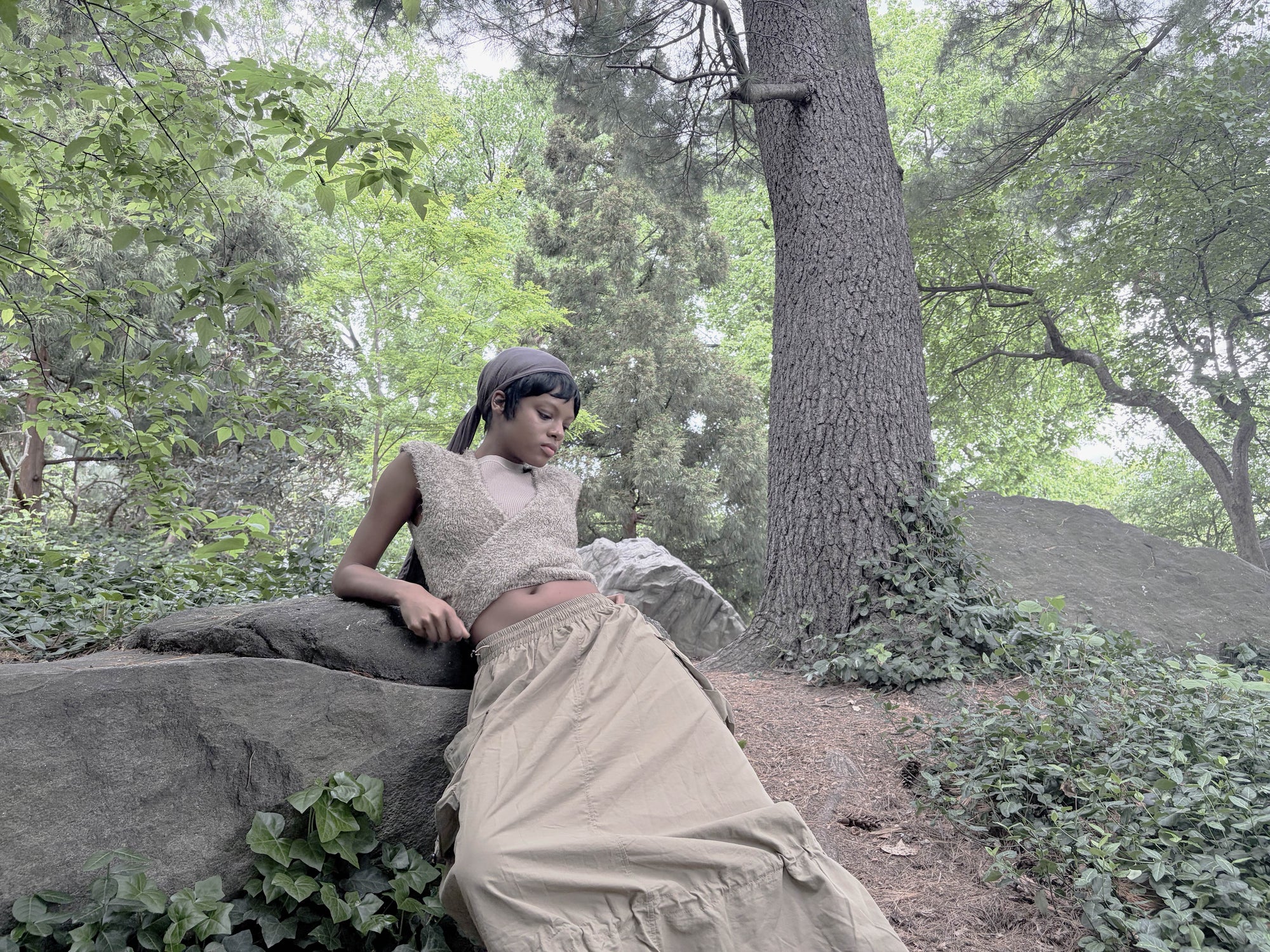 Person sitting on a rock in a forest setting