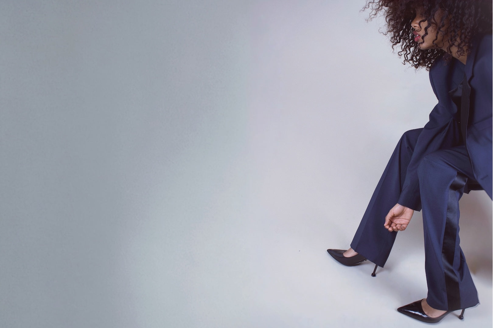 editorial studio shot of femme model in suit