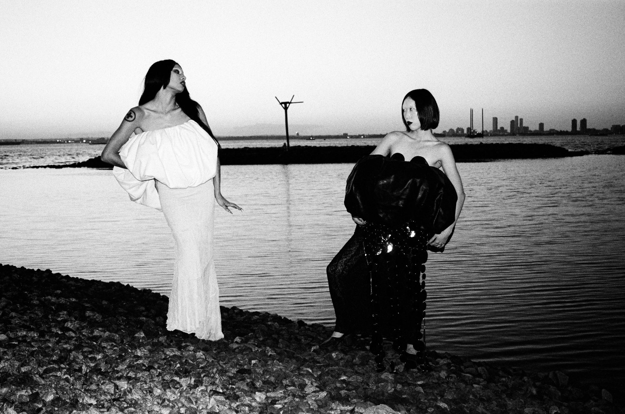 spooky couture black/white editorial shot of models posing near water
